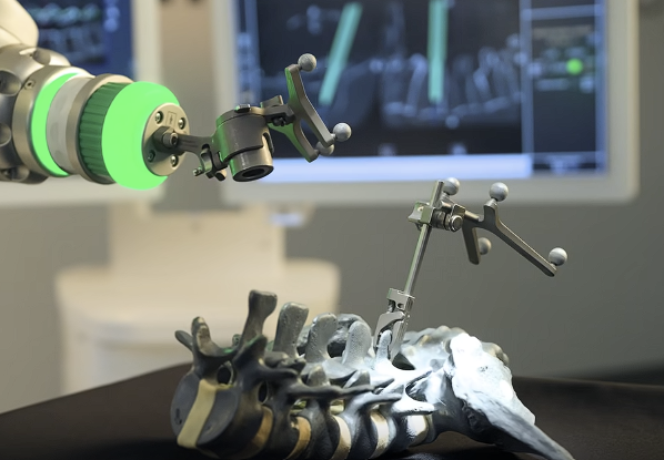 Robotic arm and tracked instrument positioned over a spine model
